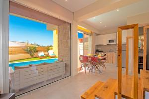 a kitchen and dining room with a view of a pool at Villa Petra Gouvia by Villa Plus in Gouvia