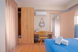 a bedroom with a bed and a desk with a chair at Villa Petra Gouvia by Villa Plus in Gouvia +12 photos