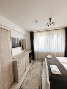 1 dormitorio con 1 cama, vestidor y TV en Cazare Vicoveancaa, en Vicovu de Jos