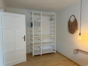 una habitación con una puerta blanca y un estante en MIA Appartements, en Innsbruck