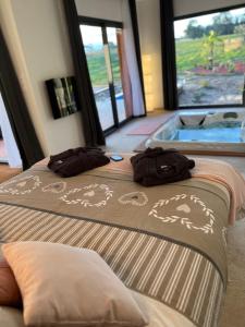 two beds in a hotel room with a hot tub at LOVE AND BULLES in Le Fleix