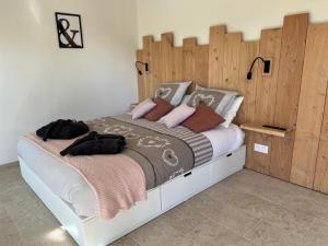 a bedroom with a large bed with a wooden headboard at LOVE AND BULLES in Le Fleix