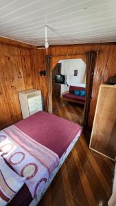 a bedroom with a bed in a room with wooden walls at Maridalba in La Coronilla