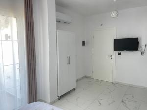 a white room with a television and a door at Villa Denis Ksamil in Ksamil