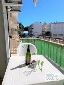 - une bouteille de vin assise sur une table sur un balcon dans l'établissement New Pins II, climatizado y a 120m de la playa, à Cambrils