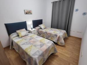a bedroom with two beds and a curtain at Casa Matele 2 bed Apt in Arona