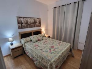 1 dormitorio con 1 cama con colcha de flores en Casa Matele 2 bed Apt, en Arona