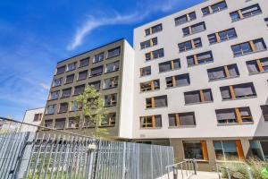 an apartment building with a fence in front of it at Apparteo Strasbourg in Strasbourg