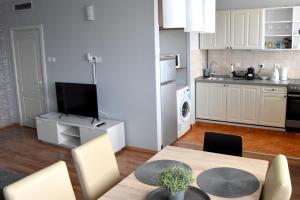 a living room with a table and a kitchen at Panorama View Apartment in Veszprém