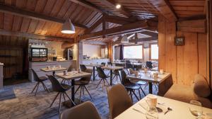 un restaurante con paredes de madera, mesas y sillas en Hôtel Le Labrador en Chamonix-Mont-Blanc