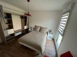 una piccola camera da letto con un letto e una finestra di L'apaisant a Houlgate