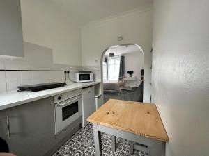 uma pequena cozinha com uma mesa no canto em Chic & Cosy Studio Apartment em Southampton