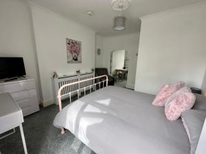um quarto com uma cama branca e uma televisão em Chic & Cosy Studio Apartment em Southampton