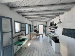 a room with a desk and a table in it at Windhouses Serifos in Serifos Chora