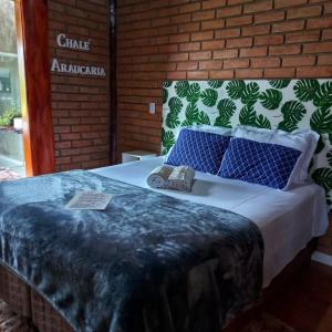 a bedroom with a bed with two shoes on it at Chalé Araucária- Vale das Pedras MG in Sapucaí-Mirim