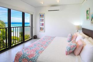 a bedroom with a bed with a view of the ocean at Beachfront Luxury with Incredible Ocean Views apts in Christ Church