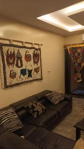 sala de estar con sofá y una foto en la pared en Studio meublé cuisine américaine, en Dakar