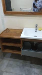 La salle de bains est pourvue d'un lavabo blanc et d'un comptoir. dans l'établissement Studio meublé cuisine américaine, à Dakar