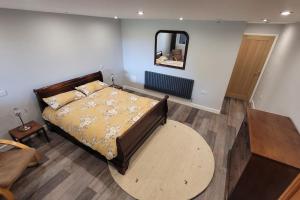 a bedroom with a bed and a mirror on the wall at Grove Lodge, Contemporary Cabin in Mendip Hills in Axbridge