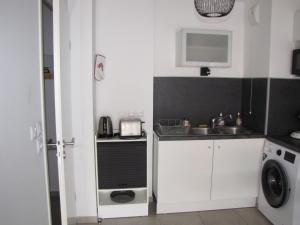una pequeña cocina con fregadero y lavadora en Bel appartement , à 2km du bassin d'Arcachon, en La Teste-de-Buch