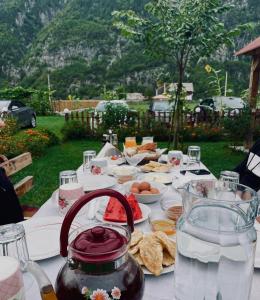 ein weißer Tisch mit Essen und einem Tischtuch drauf in der Unterkunft Guesthouse Prrockaj Theth in Theth