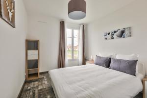 a white bedroom with a large bed and a window at 123home-Le park side in Chessy