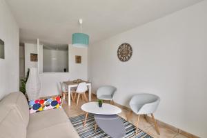 a living room with a couch and a table and chairs at 123home-Le park side in Chessy