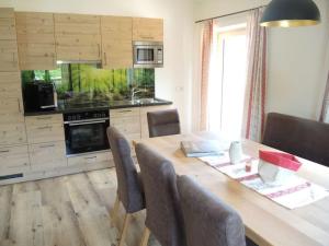 uma cozinha com uma mesa de madeira com cadeiras e uma sala de jantar em Ferienwohnung Ochsenhorn in Lofer 100 m² / 4-8 P. em Lofer