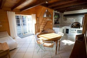 a kitchen with a table and a bed in a room at Gîte et Roulotte dans les Vosges in Remiremont