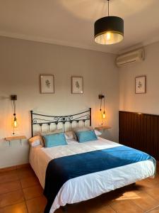 a bedroom with a large bed with blue pillows at Casa Rural Mirador de la Alcaidía in Hornachuelos