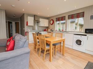 a kitchen and dining room with a table and chairs at Holly Lodge in Preston