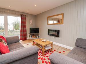 a living room with two couches and a table at Holly Lodge in Preston