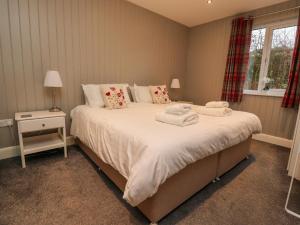 a bedroom with a large bed with towels on it at Holly Lodge in Preston