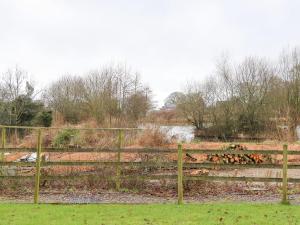 a wooden fence in a field next to a river at Holly Lodge in Preston