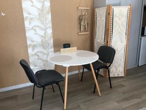 Au Petit C'Alain في تولوز: طاولة بيضاء وكراسي في غرفة