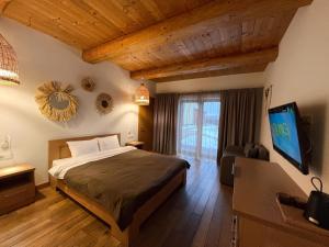 a bedroom with a bed and a flat screen tv at Eden Resort in Yasnogorodka