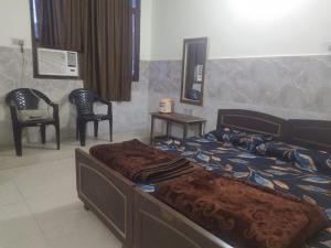 1 dormitorio con 1 cama y 2 sillas en Shree Radha Krishna Guest House By WB Inn en Harchandpur