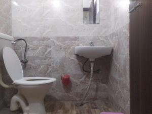 y baño con aseo y lavamanos. en Shree Radha Krishna Guest House By WB Inn en Harchandpur
