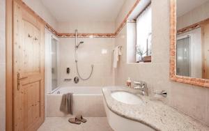 ein Badezimmer mit einem Waschbecken und einer Badewanne in der Unterkunft Radhof in Villanders