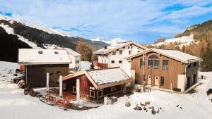 a group of buildings in the snow with mountains at stettli resort in Parpan
