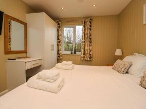 a bedroom with a large white bed and a window at Oak Lodge in Preston