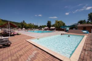 a large swimming pool with people in the water at Camping Paradis le Rocher de la Granelle in Le Bugue