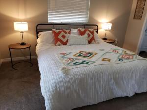 a bedroom with a white bed with two lamps at Shell near the Sea, 2-Br Pet Friendly Home in Venice
