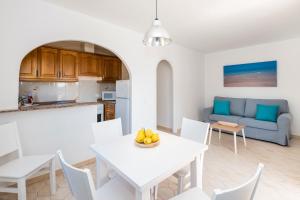 a kitchen and living room with a white table and chairs at Girasols Gardens Sup in Son Bou