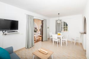 een witte woonkamer met een tafel en stoelen bij Girasol Garden Superior 2 in Son Bou