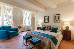 1 dormitorio con 1 cama grande y 1 silla azul en Casa Penelope, en Lucca