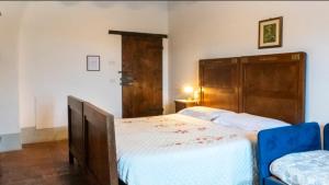 una camera con un grande letto con testiera in legno di Agriturismo San Rocco Verucchio a Verucchio