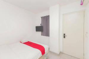 um quarto branco com uma cama e uma porta em RedDoorz near Kaza Mall Surabaya em Plosobegem