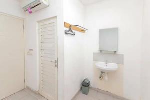 a white bathroom with a sink and a mirror at RedDoorz near Kaza Mall Surabaya in Plosobegem +17 photos