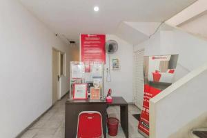um pequeno quarto com uma mesa e um banco vermelho em RedDoorz near Kaza Mall Surabaya em Plosobegem